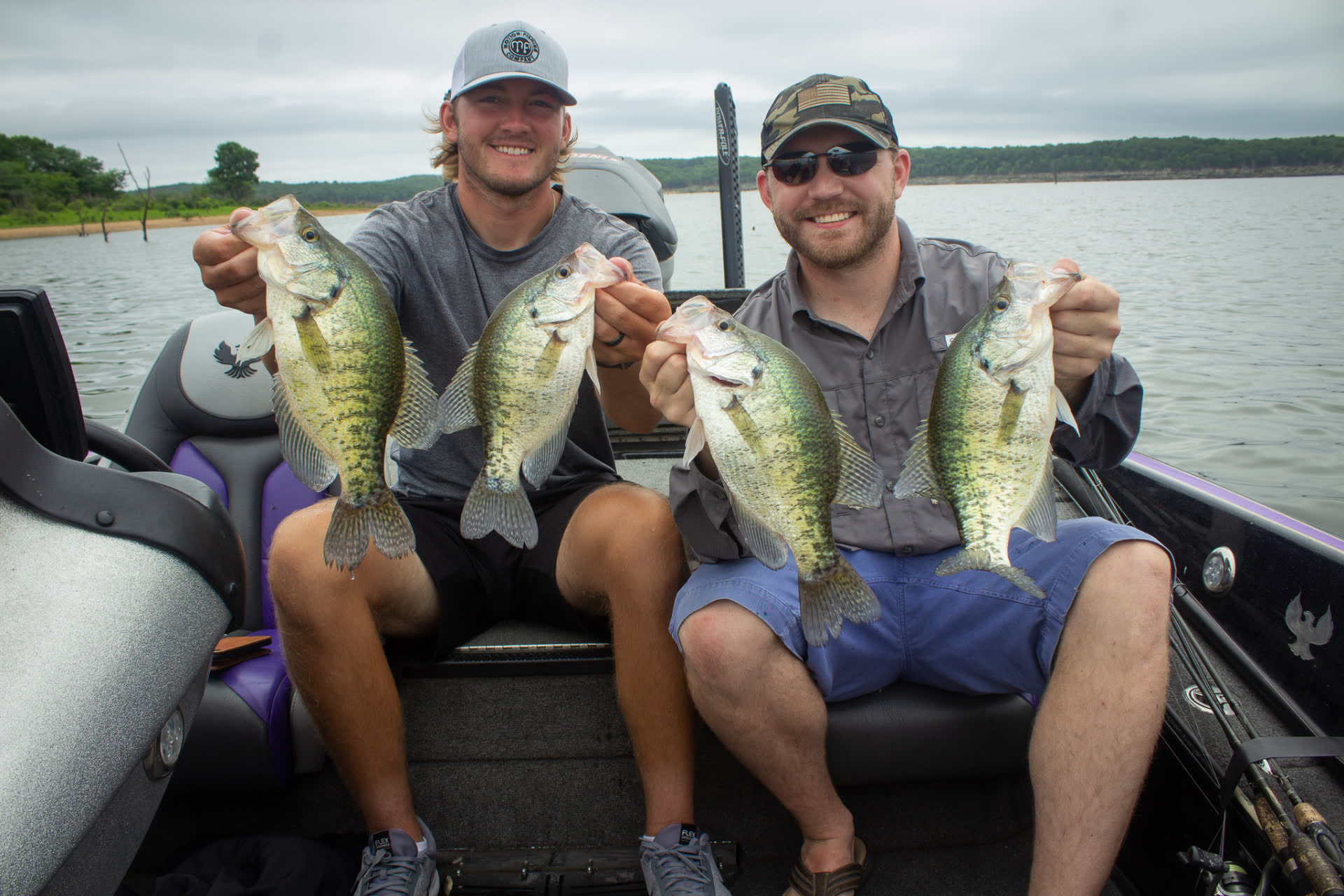 Two anglers in a boat holding a limit of large Missouri crappie