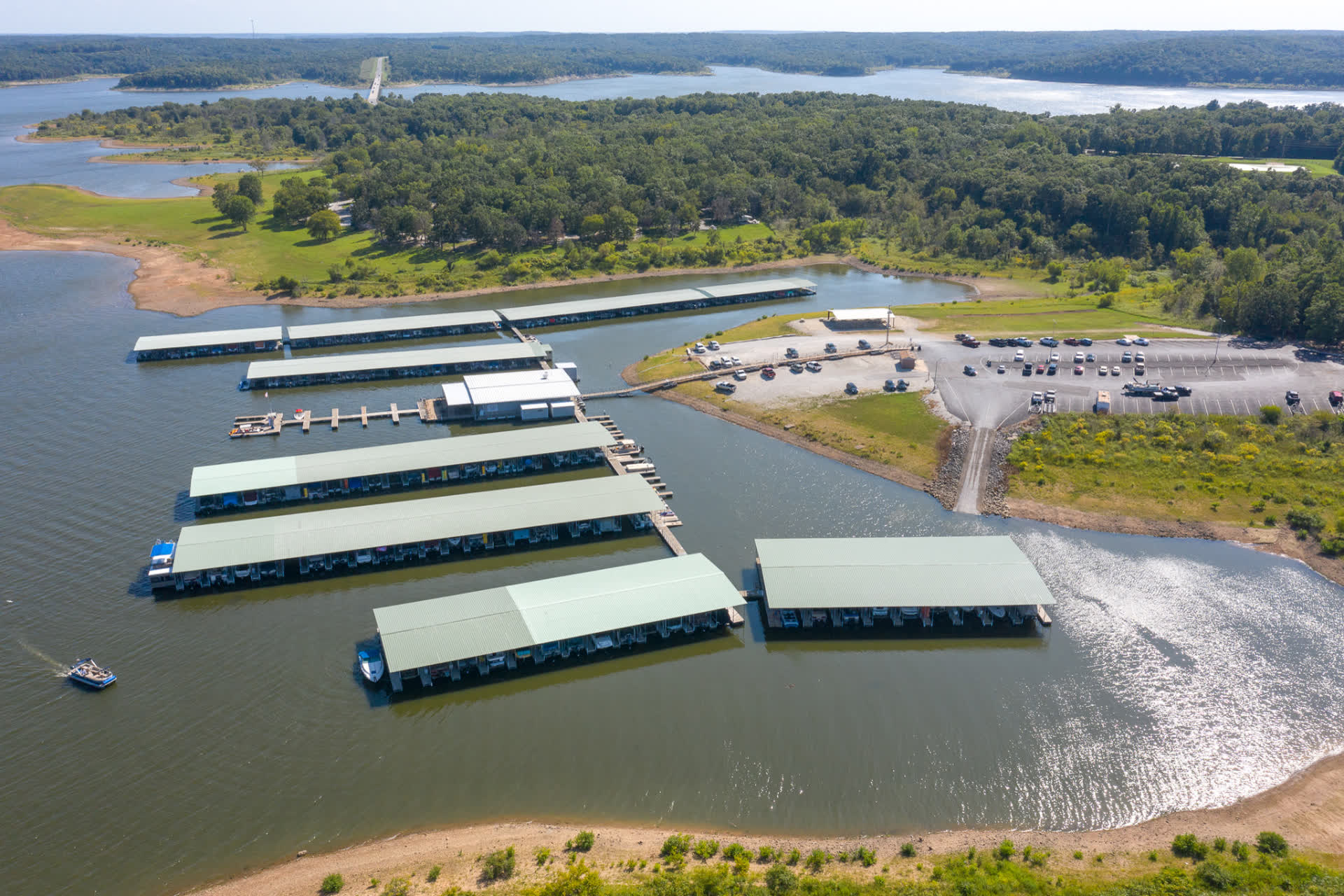 Aerial view of a Missouri lake marina with covered slips, ramp and parking